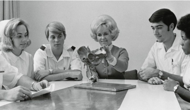 Myrna Pickard examining a model of a pelvis with her nursing students. Courtesy, University of Texas at Arlington. College of Nursing Records, Special Collections, UTA Libraries