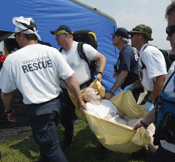 rescue squad carries a woman to a medical tent
